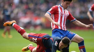 Atletico Madrid's Argentinian forward Luciano Vietto (L) falls next to Sporting Gijon's defender Jorge Mere during the Spanish league football match Real Sporting de Gijon vs Club Atletico de Madrid at El Molinon stadium in Gijon on March 19, 2016. / AFP PHOTO / MIGUEL RIOPA